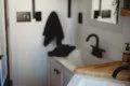 Contemporary bathroom with black fixtures, wood accents, and white sink in a Fairbanks Alaska treehouse rental