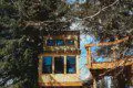 Elevated wooden treehouse cabin with deck nestled in the Fairbanks, Alaska forest
