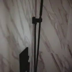 Close-up of a modern black shower fixture against marble tile in a Fairbanks Alaska treehouse rental