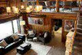 Large open-concept lodge interior with high ceilings, chandelier lighting, sofas, and loft seating in Fairbanks, Alaska