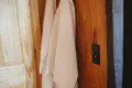Two white robes hanging on a wooden wall inside a Fairbanks Alaska treehouse rental