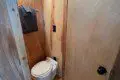 Compact wood-paneled toilet room in a rustic Fairbanks Alaska treehouse rental