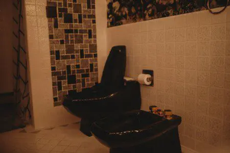 Black soaking bathtub with tiled backsplash in a Fairbanks Alaska treehouse bathroom