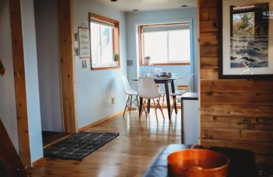 Bright dining area with white chairs and wooden floors in a Fairbanks Alaska vacation rental