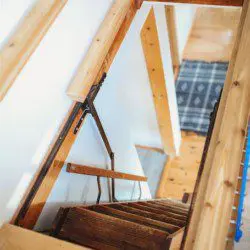 View looking down wooden stairs from a loft inside a Fairbanks Alaska treehouse rental