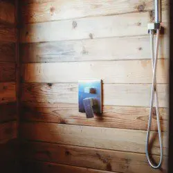 Enjoy a warm shower in this rustic wood-paneled bathroom—perfect for relaxing after Alaska adventures or wedding celebrations.