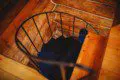 Wood and metal spiral staircase in a log-walled Fairbanks Alaska treehouse rental