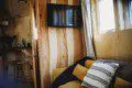 Interior view of treehouse rental in Fairbanks Alaska with wooden walls, TV, and yellow couch