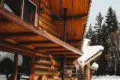 Wooden log treehouse with spiral stairs and snowy surroundings in Fairbanks Alaska  Caption: