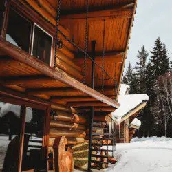 Wooden log treehouse with spiral stairs and snowy surroundings in Fairbanks Alaska  Caption: