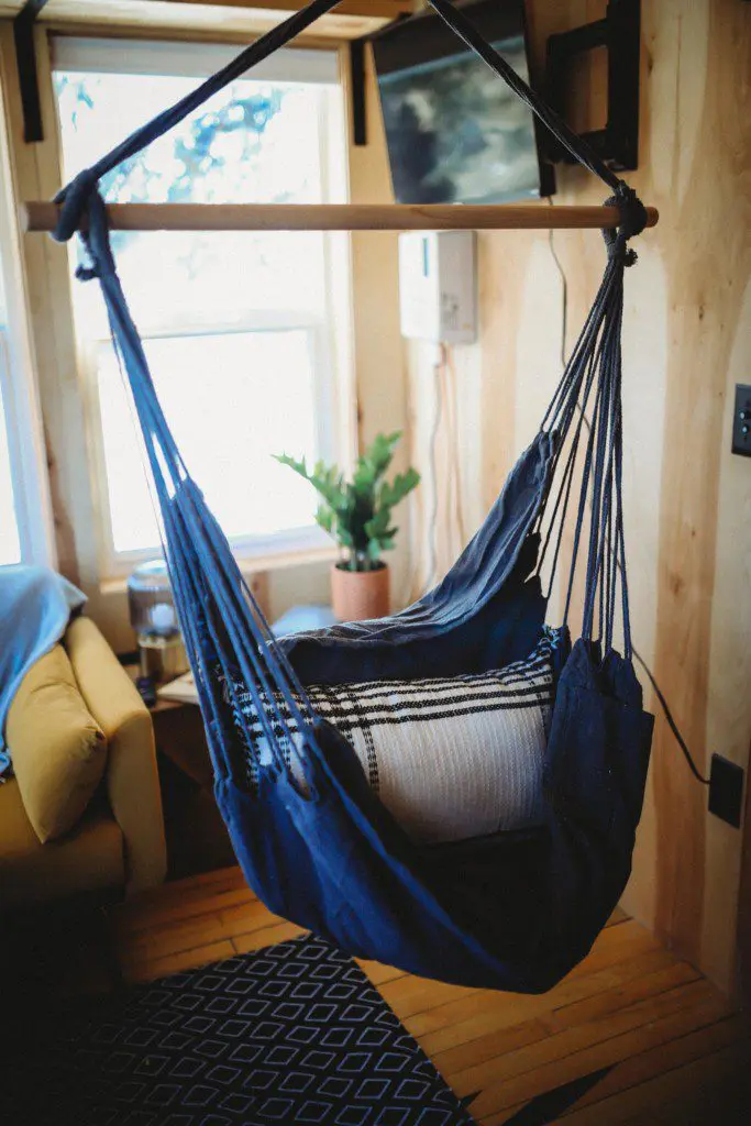 Blue hanging hammock chair by a window in a cozy Fairbanks Alaska treehouse rental