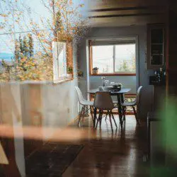  Reflection of dining area and autumn trees seen through a window in a Fairbanks Alaska treehouse