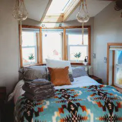 Comfy bed with pillows and soft blanket inside a Fairbanks Alaska treehouse rental