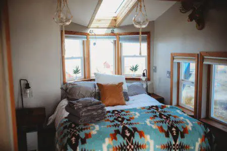 Comfy bed with pillows and soft blanket inside a Fairbanks Alaska treehouse rental