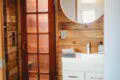 Bathroom with white vanity, round mirror, and wood accents in a Fairbanks Alaska treehouse rental