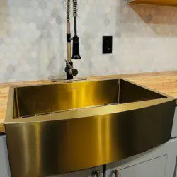 Shiny gold farmhouse kitchen sink with modern faucet in a Fairbanks Alaska treehouse rental