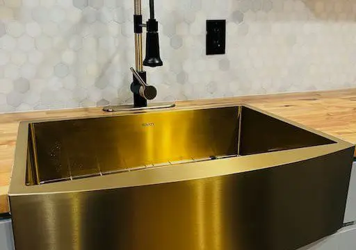 Shiny gold farmhouse kitchen sink with modern faucet in a Fairbanks Alaska treehouse rental