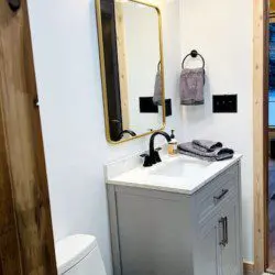Contemporary bathroom with white vanity, black faucet, and wood accents in a Fairbanks Alaska rental