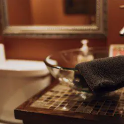 Modern rustic bathroom with glass vessel sink and mosaic countertop in a Fairbanks Alaska adventure lodge