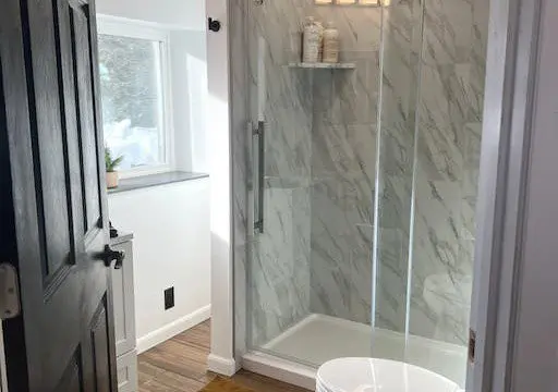 Bright bathroom with glass walk-in shower and natural light in a Fairbanks Alaska treehouse rental