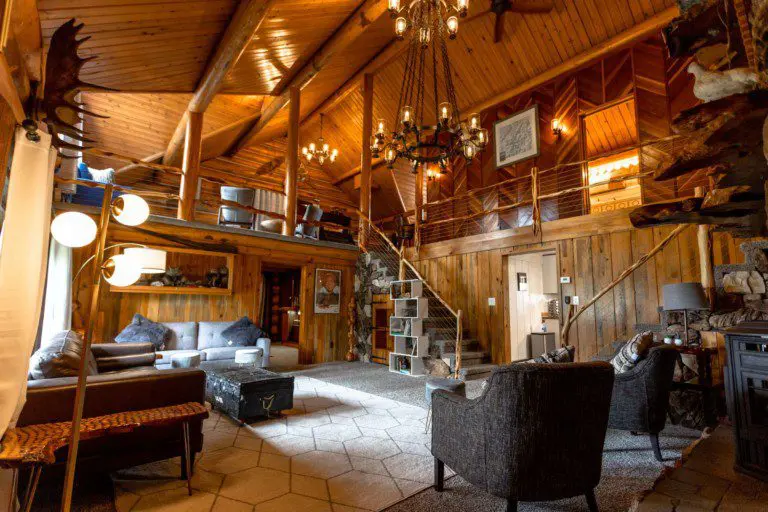 Spacious wood-paneled lodge with loft, chandeliers, and cozy seating areas in Fairbanks, Alaska