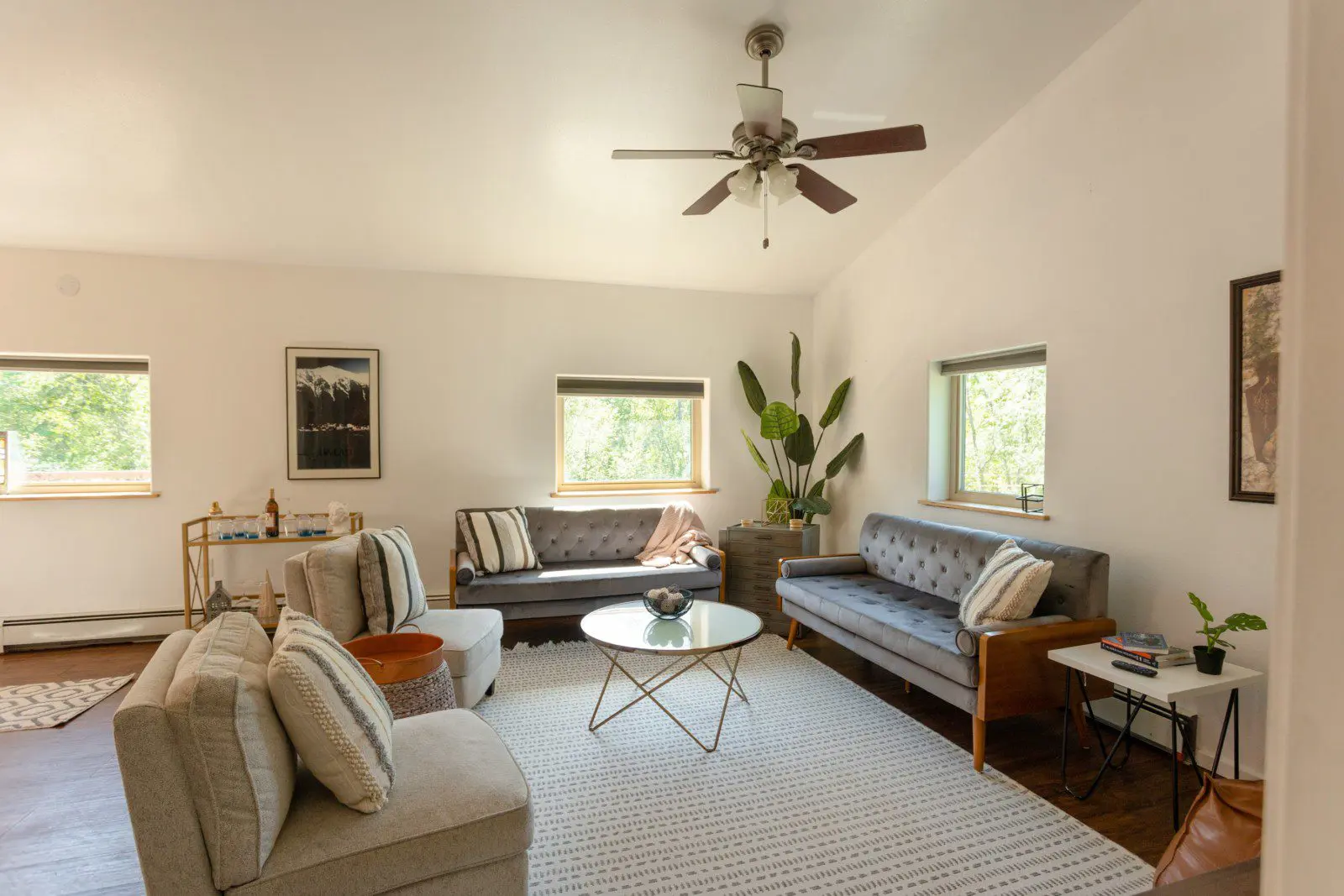 Well-lit living room with neutral-toned furniture, ceiling fan, and natural window light in a Fairbanks Alaska rental