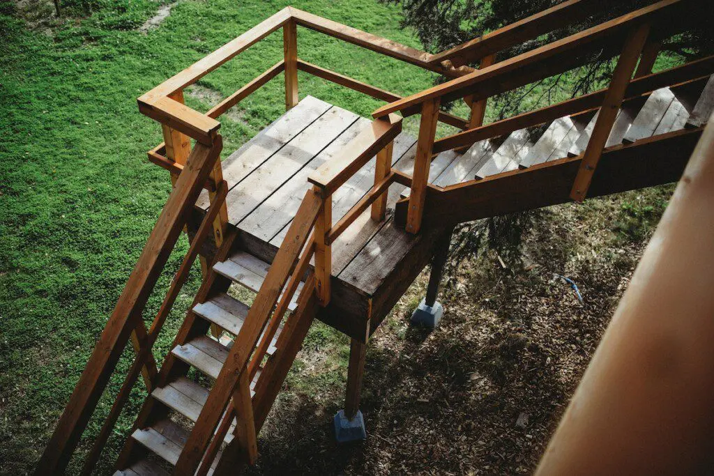 Wooden staircase and landing leading up to a treehouse rental in Fairbanks Alaska