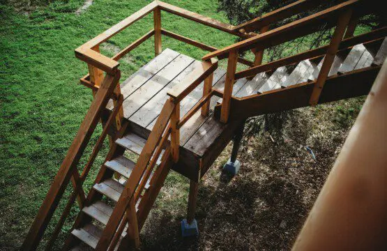 Wooden staircase and landing leading up to a treehouse rental in Fairbanks Alaska