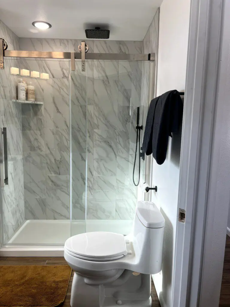 Treehouse bathroom with marble walk-in shower and black fixtures in Fairbanks, Alaska