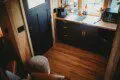 Compact kitchen area with dark cabinets, wooden floor, and window view in a Fairbanks Alaska treehouse rental