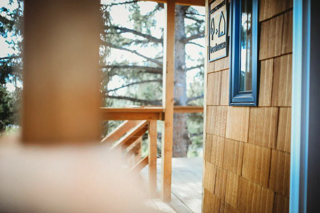 Wooden staircase and landing leading up to a treehouse rental in Fairbanks Alaska