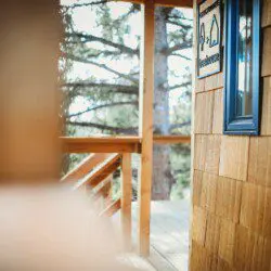 Wooden staircase and landing leading up to a treehouse rental in Fairbanks Alaska