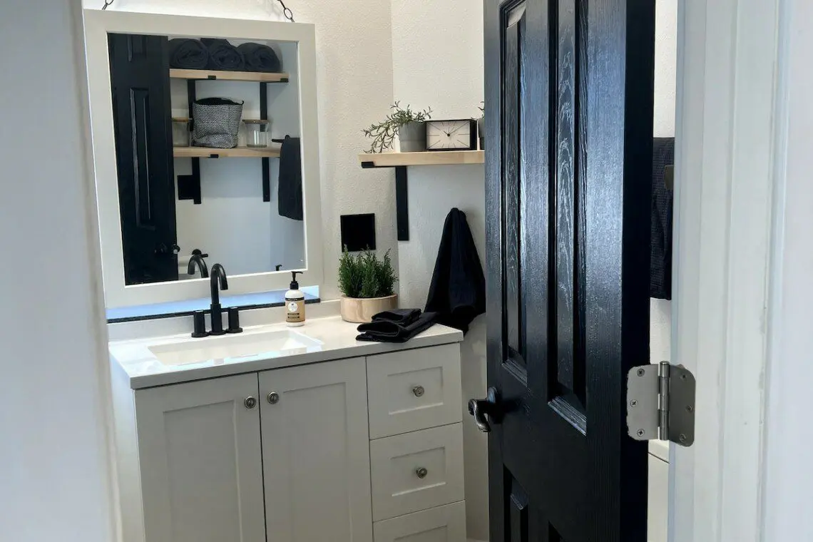 Compact and modern bathroom with black and white accents in a Fairbanks treehouse rental