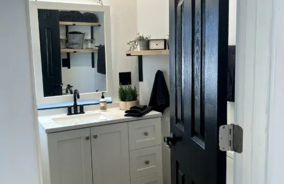 Compact and modern bathroom with black and white accents in a Fairbanks treehouse rental