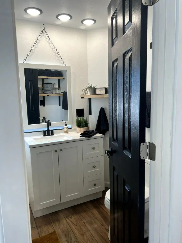 Compact and modern bathroom with black and white accents in a Fairbanks treehouse rental