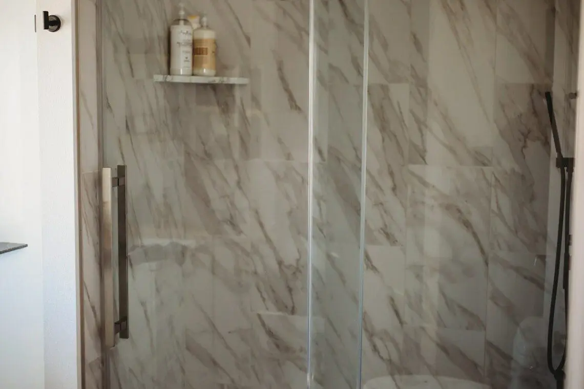 Treehouse bathroom with marble walk-in shower and black fixtures in Fairbanks, Alaska