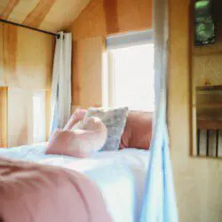 Warm and inviting treehouse bedroom with soft pillows and natural light in Fairbanks, Alaska