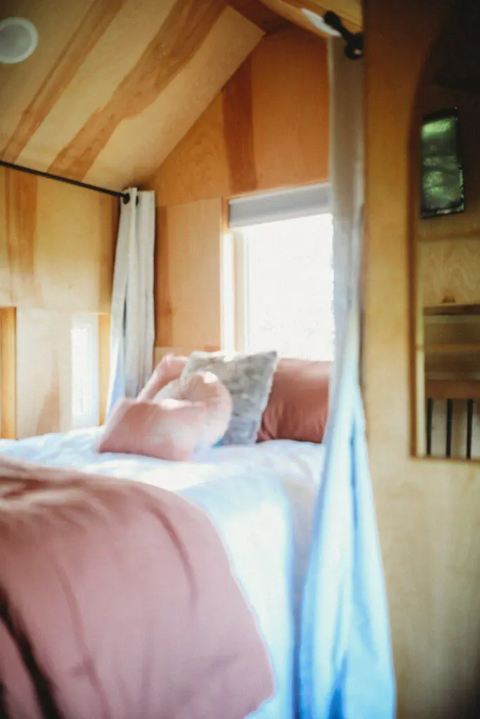 Warm and inviting treehouse bedroom with soft pillows and natural light in Fairbanks, Alaska