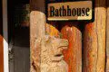 Wooden bathhouse sign mounted on a log wall at a rustic lodge in Fairbanks, Alaska