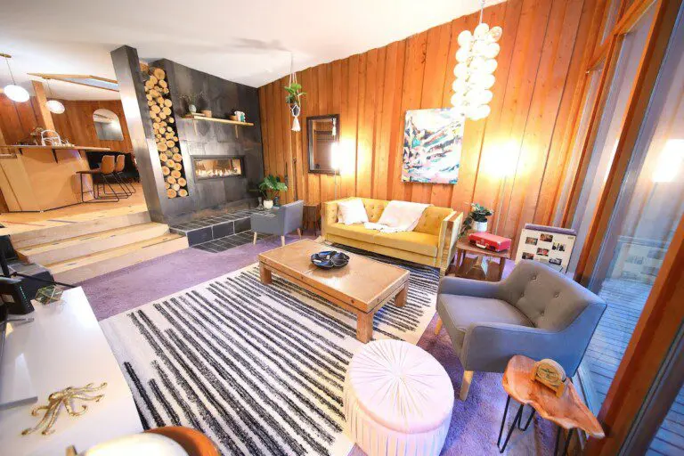 Mid-century modern living room with fireplace in a cozy Alaska treehouse rental near Fairbanks, ideal for weddings or getaways