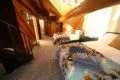 Rustic loft bedroom with two beds, patterned blankets, and log cabin walls in Fairbanks Alaska