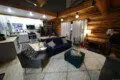 Modern open-concept living area with navy couch, kitchen, and spiral staircase in a Fairbanks Alaska treehouse rental