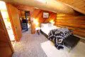 Rustic log cabin bedroom with cozy bedding and spiral staircase in Fairbanks Alaska