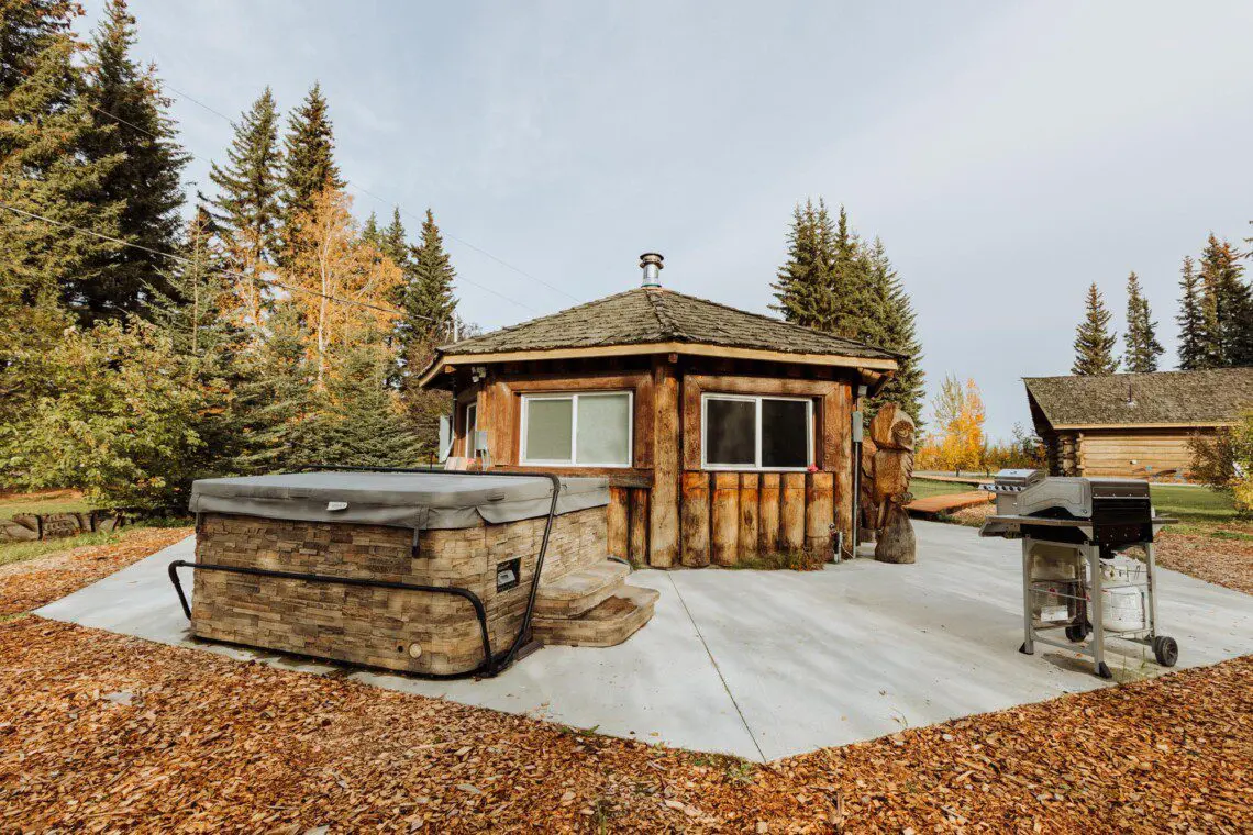 Log cabin with hot tub and grill in a wooded Fairbanks Alaska setting