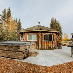 Log cabin with hot tub and grill in a wooded Fairbanks Alaska setting
