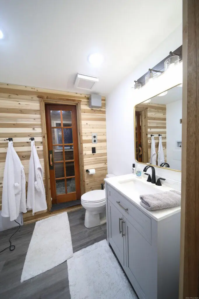 Rustic wood-accented bathroom with white vanity and natural light in Fairbanks Alaska