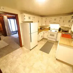 Rustic kitchen with white cabinets and wood accents in a Fairbanks Alaska cabin