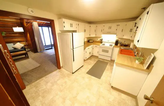 Rustic kitchen with white cabinets and wood accents in a Fairbanks Alaska cabin