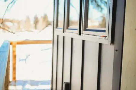 Wooden staircase built among snow-covered trees leading up to a treehouse in Fairbanks, Alaska.