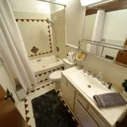 Warm cabin-style bathroom in Fairbanks Alaska with wooden ceiling, soaking tub, and tile floors